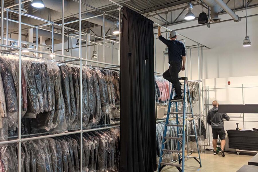 man installing warehouse clothing racks for retail