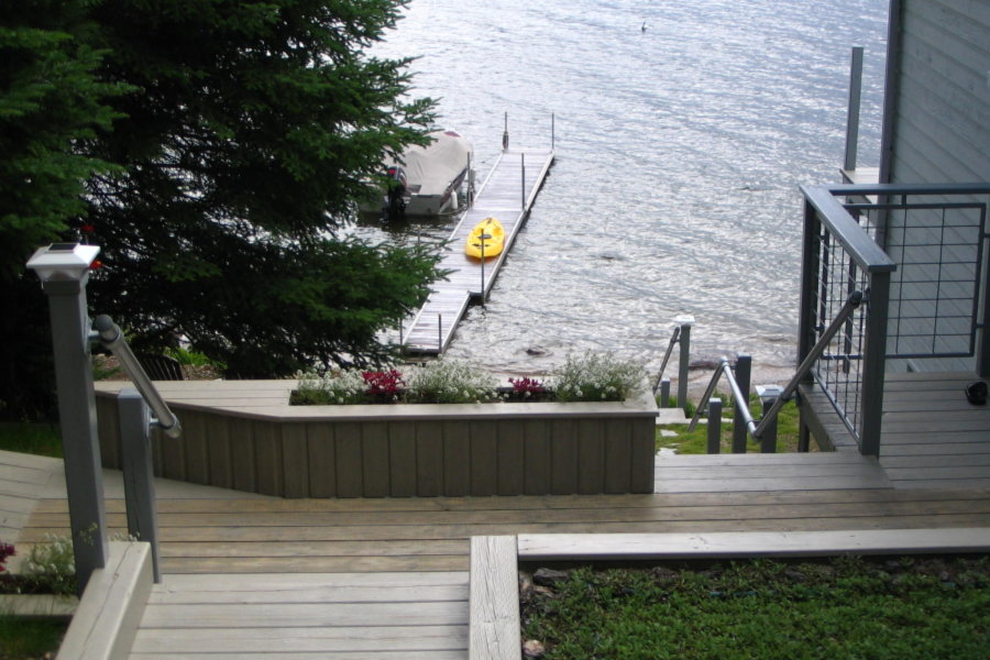 lake front cottage with wood deck and metal handrails