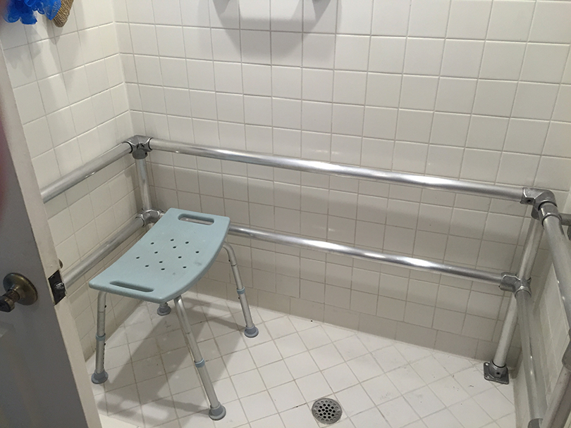 shower with handrails and chair
