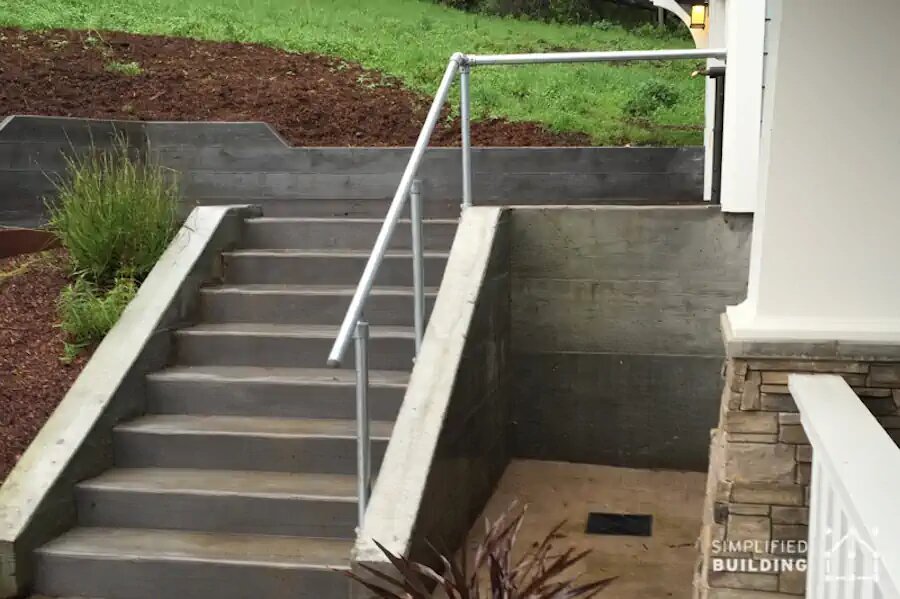 cement steps to driveway with handrail