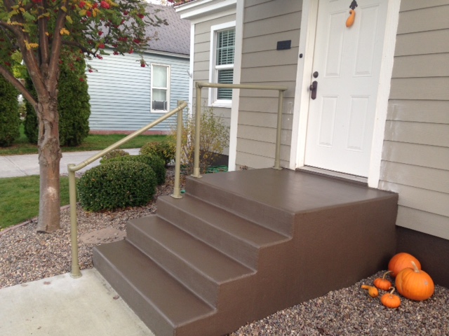 concrete front steps with gold painted railing