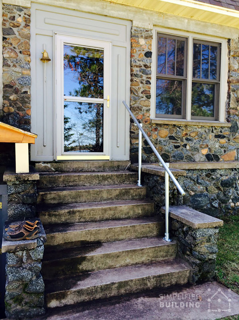 stone step front porch with metal handrail