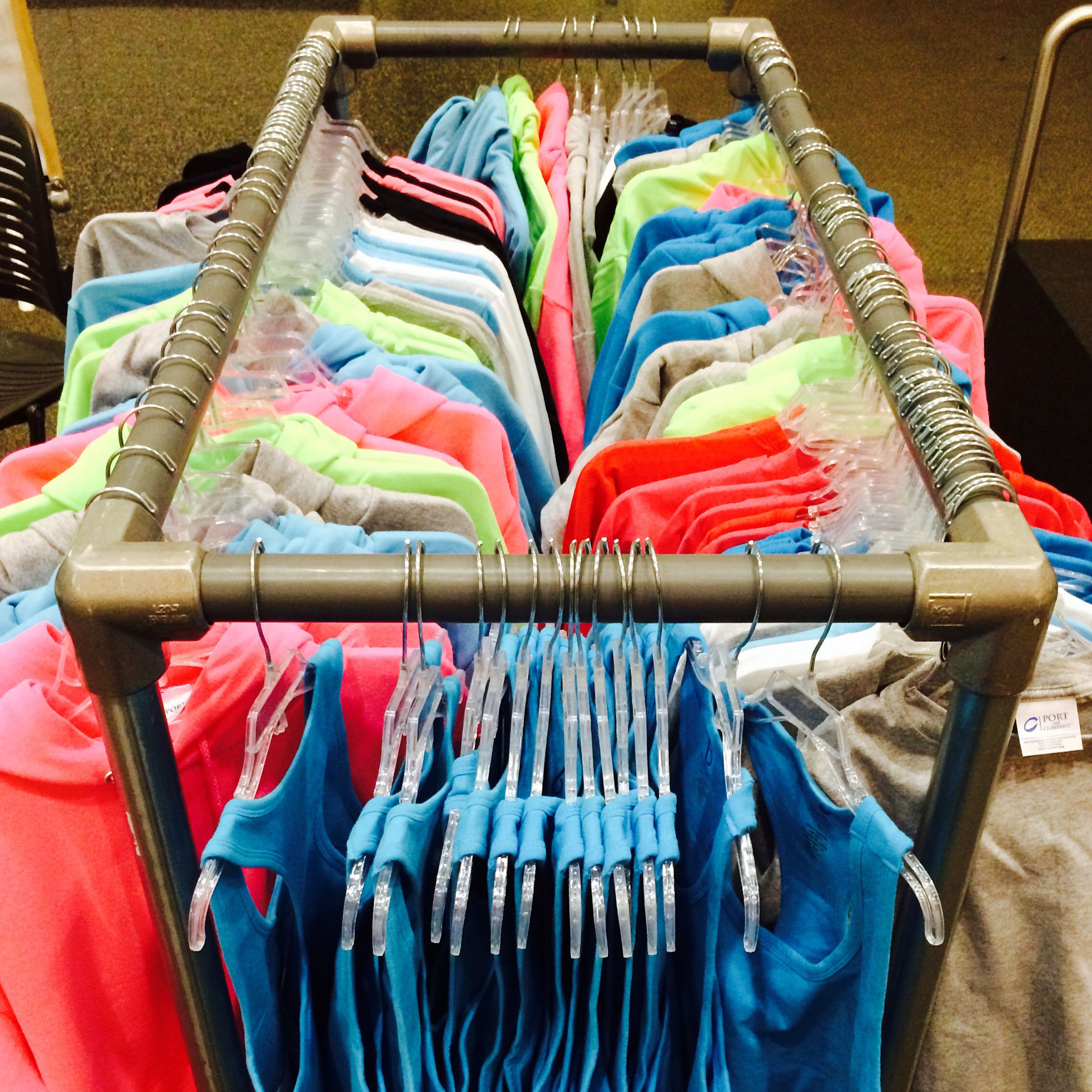 small rectangular clothing rack with many colored shirts